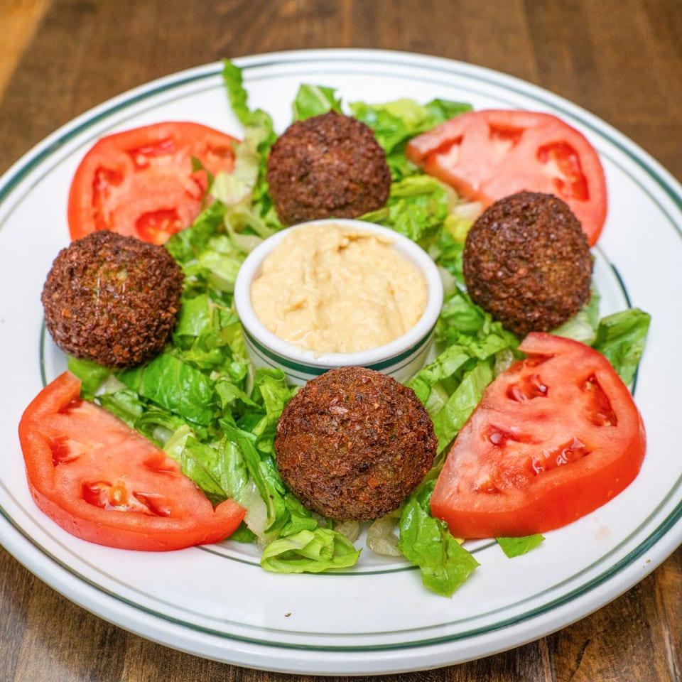 Falafel served with hummus, lettuce and tomatoes.