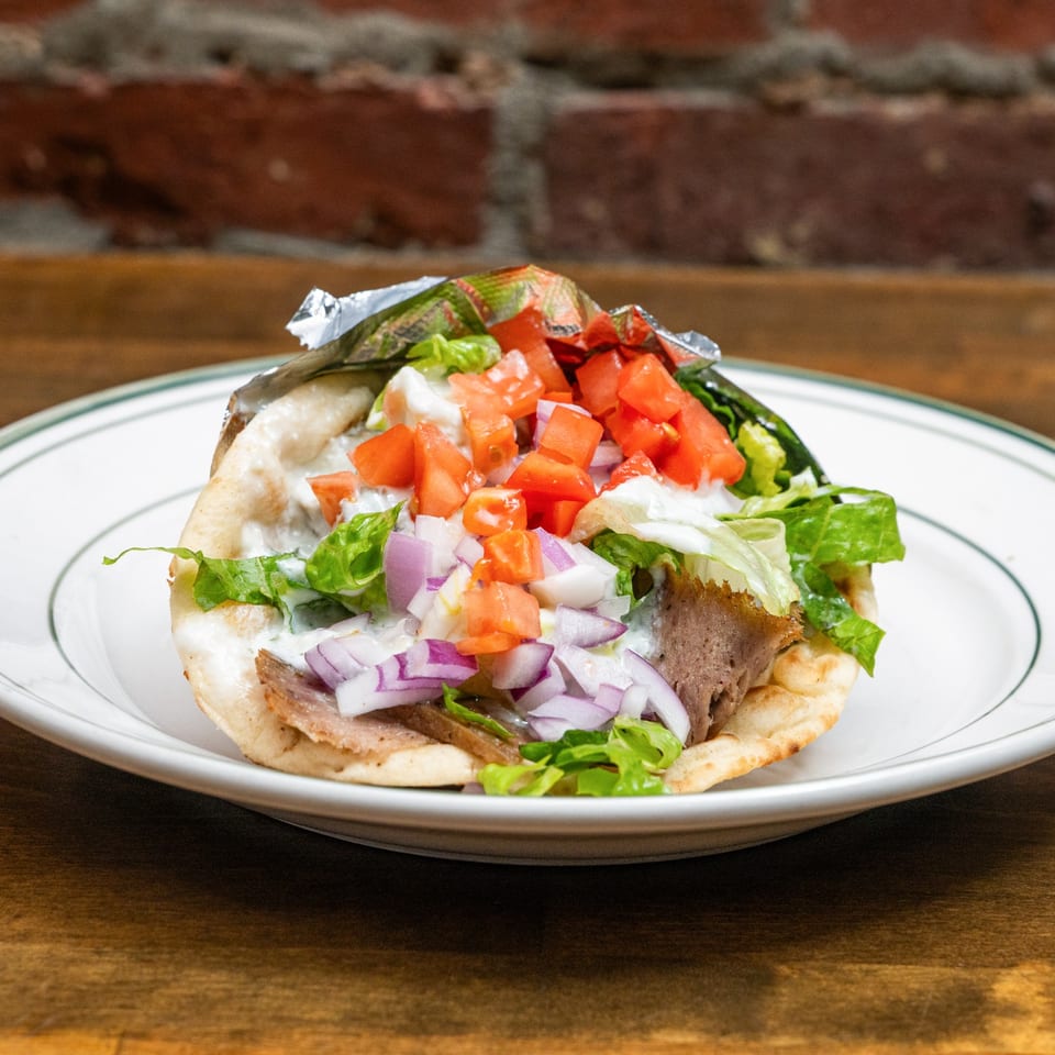 Gyro pita with vegetables and tzatziki.