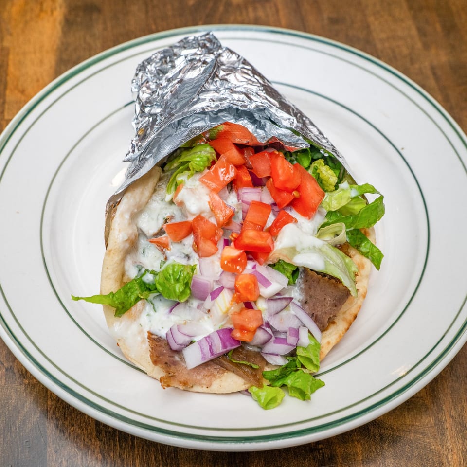 Overhead view of gyro pita with vegetables and tzatziki.